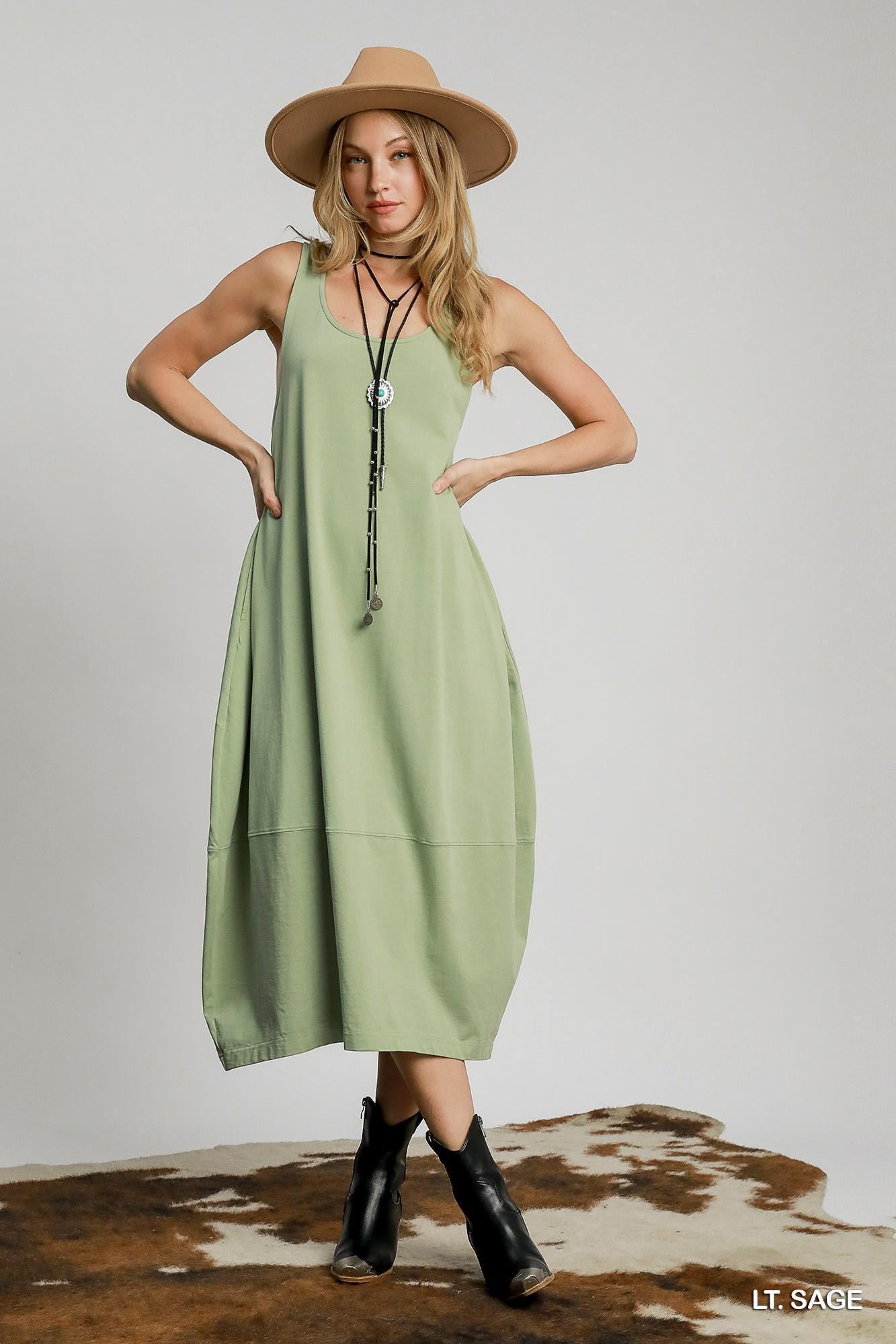 Woman wearing light sage sleeveless midi dress, relaxed fit