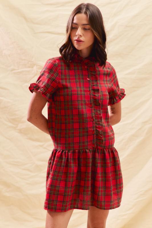 Woman wearing a red plaid dress against a beige background