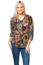 Sno Skins light poly crinkle top in autumn botanical print with V-neckline and gathered sleeve detail, displayed on an urban chic model.
