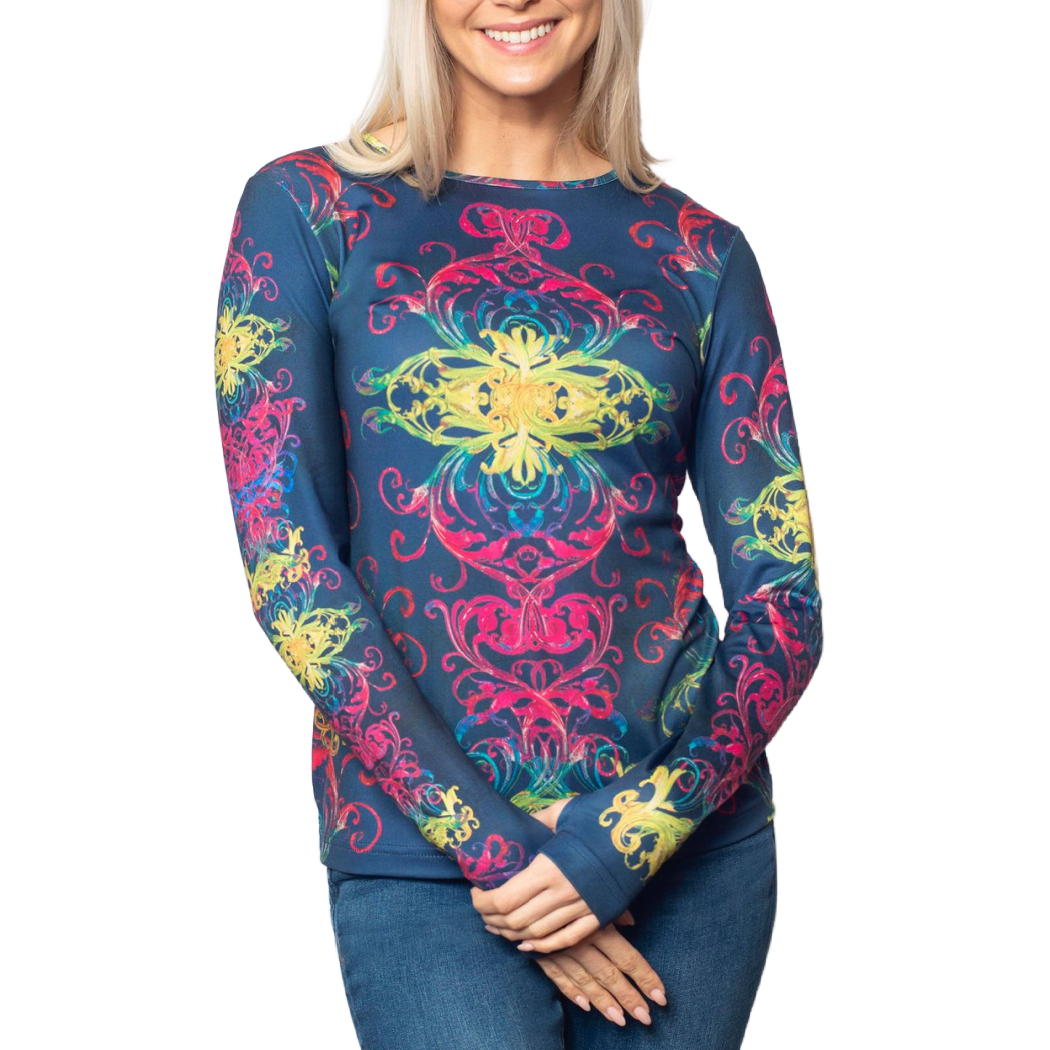 A smiling blonde woman wearing a long-sleeve crewneck top with a vibrant, multicolored mandala pattern on a dark blue base, paired with blue jeans, set against a plain white background.