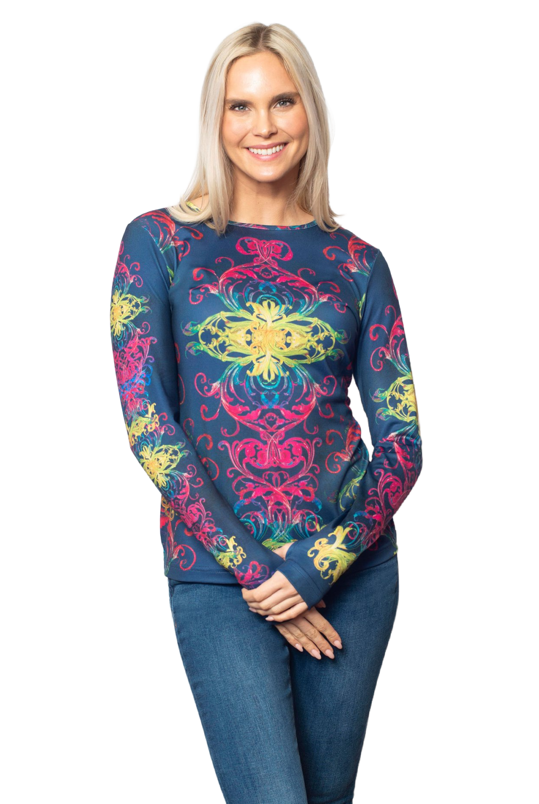 A smiling blonde woman wearing a long-sleeve crewneck top with a vibrant, multicolored mandala pattern on a dark blue base, paired with blue jeans, set against a plain white background.