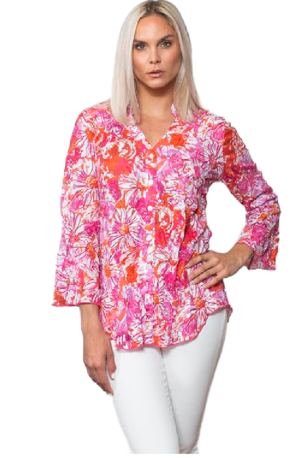 A woman modeling a vibrant pink, orange, and white floral long-sleeve blouse with white pants, set against a plain white background.
