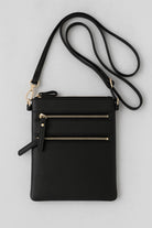 “Convertible black wristlet and shoulder bag with gold zippers”