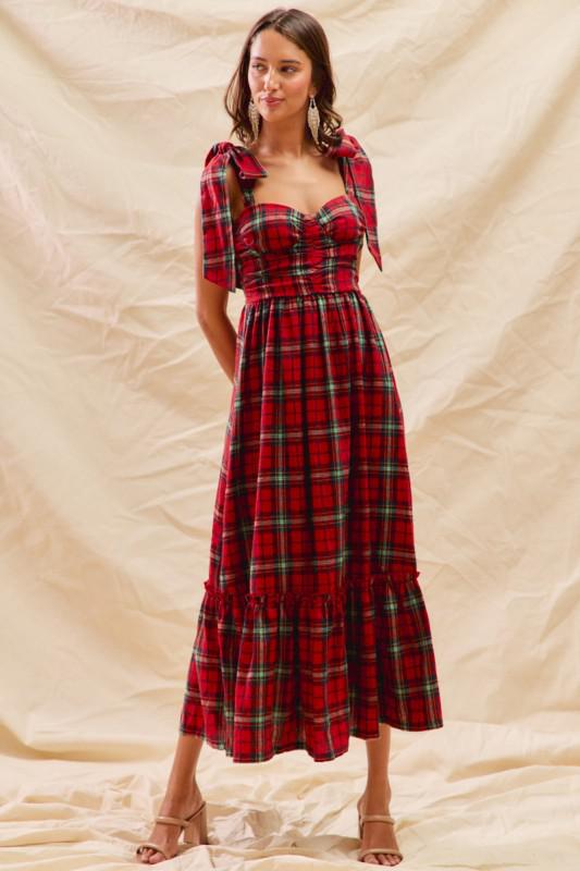 Woman wearing red plaid holiday maxi dress with bow-tied shoulders and sweetheart neckline from Petunias of Naples