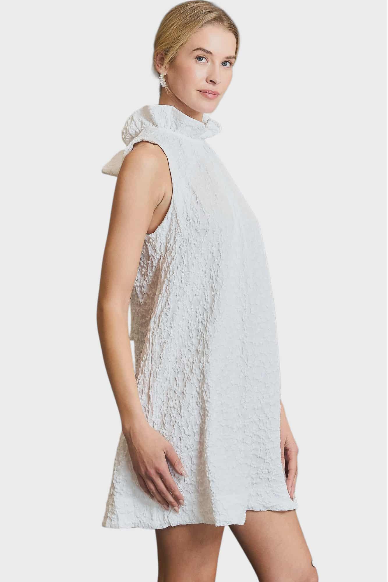 Woman wearing a white lace dress on a plain background, SIDE VIEW