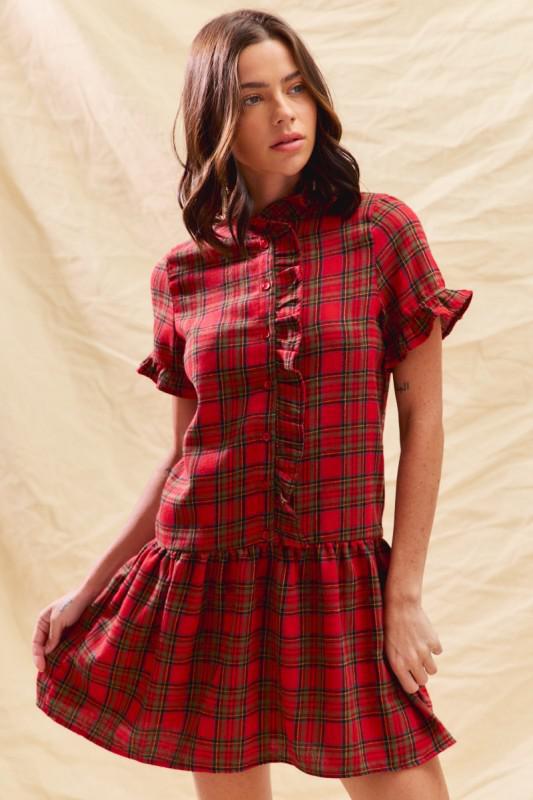 Woman wearing a red plaid dress against a beige background