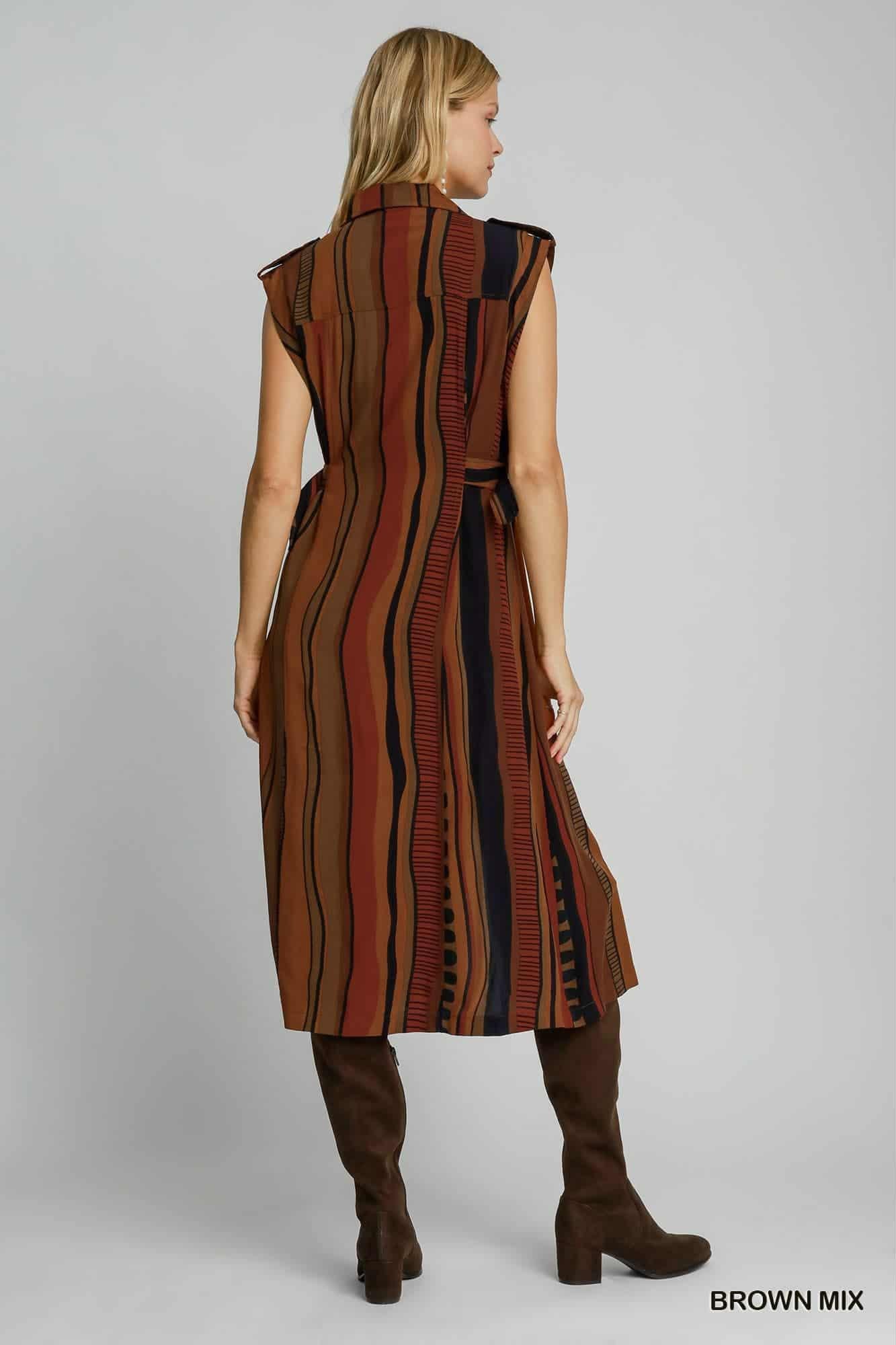 Woman wearing a brown striped dress with a belt on a gray , background, back view of dress