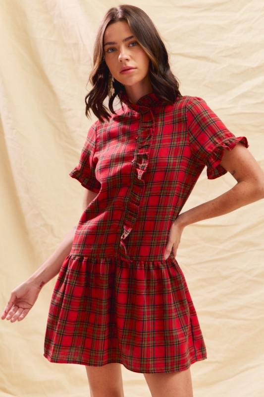 Woman wearing a red plaid dress against a beige background