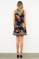 Woman wearing a floral dress with a white background, Back View