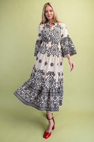 Woman wearing a black and cream patterned dress on a green background