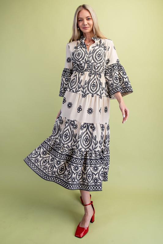 Woman wearing a black and cream patterned dress on a green background