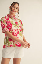 Woman wearing a floral blouse with pink roses on a beige background