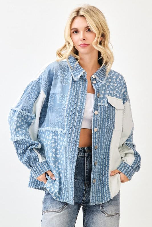 Woman wearing a blue patterned jacket with white accents on a light gray background