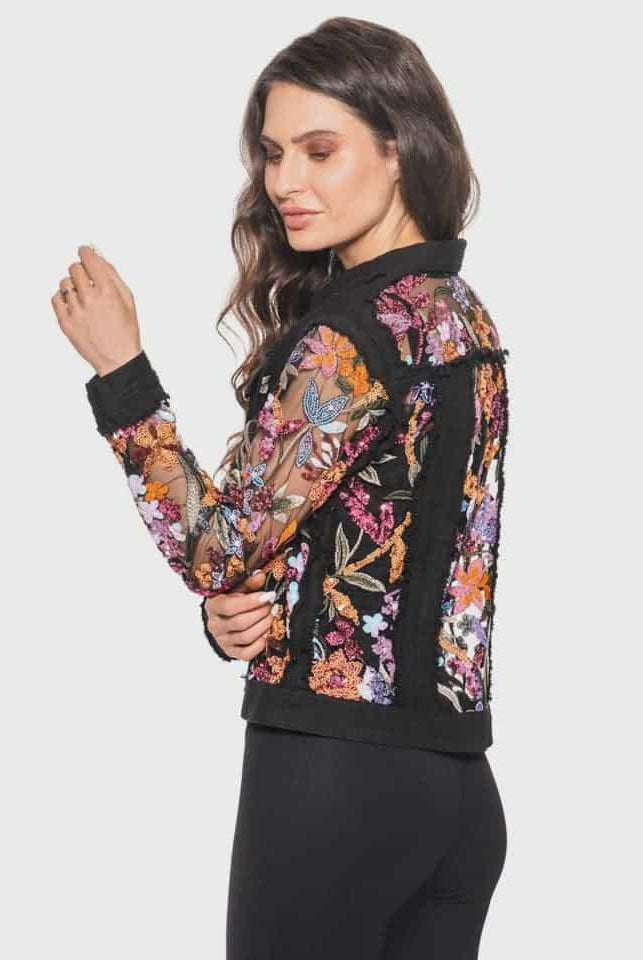Woman wearing a black jacket with colorful floral pattern made of  sequins and embroidery on a white background