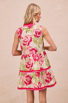 Woman wearing a floral dress with pink roses on a beige background, BACK VIEW