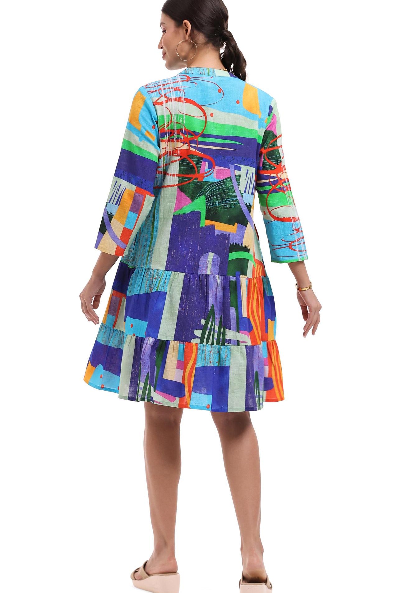 Woman wearing a colorful Parsley & Sage 100% cotton tiered dress with abstract patchwork print back View