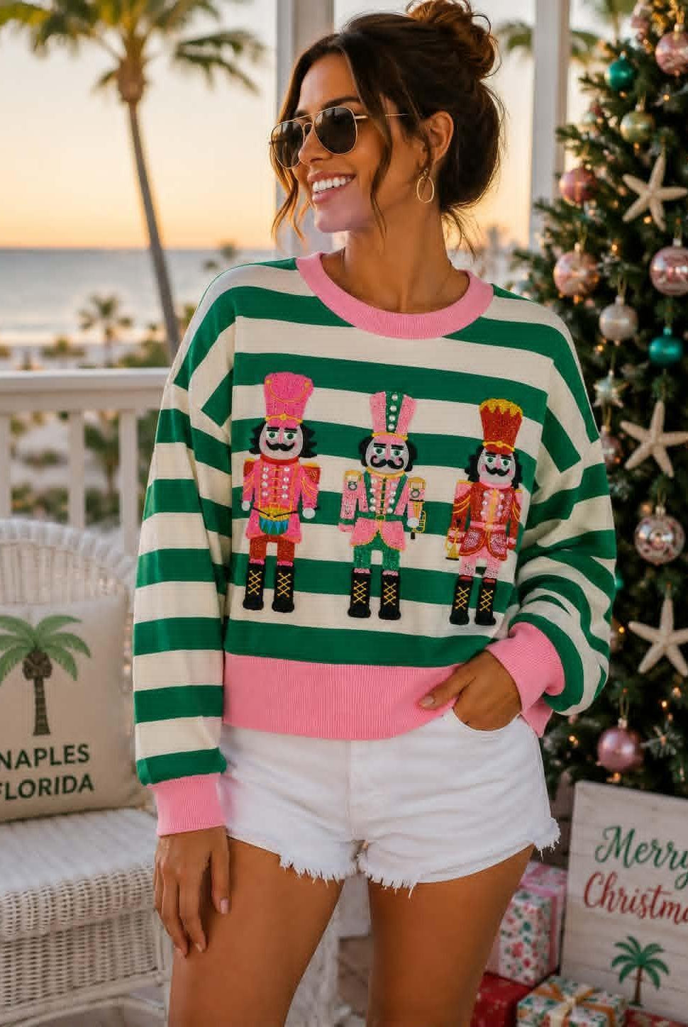 SHIRALEAH green and ivory striped knit top with pink trim and three colorful embellished nutcrackers.