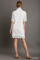 Model wearing off-white floral lace shirt dress with short sleeves and scalloped hem, styled with nude heels, Back View
