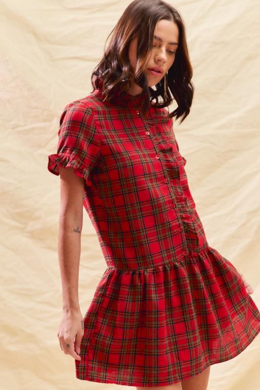 Woman wearing a red plaid dress against a beige background