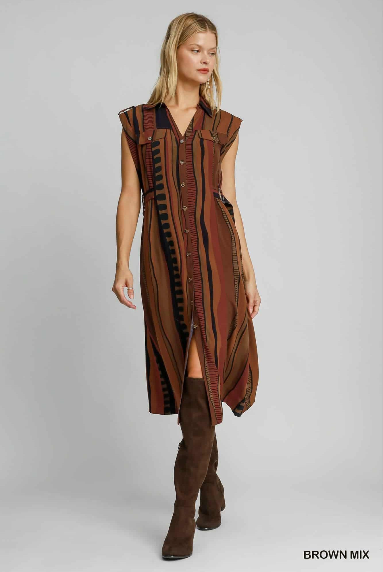 Full view of sleeveless collared brown striped dress styled with boots