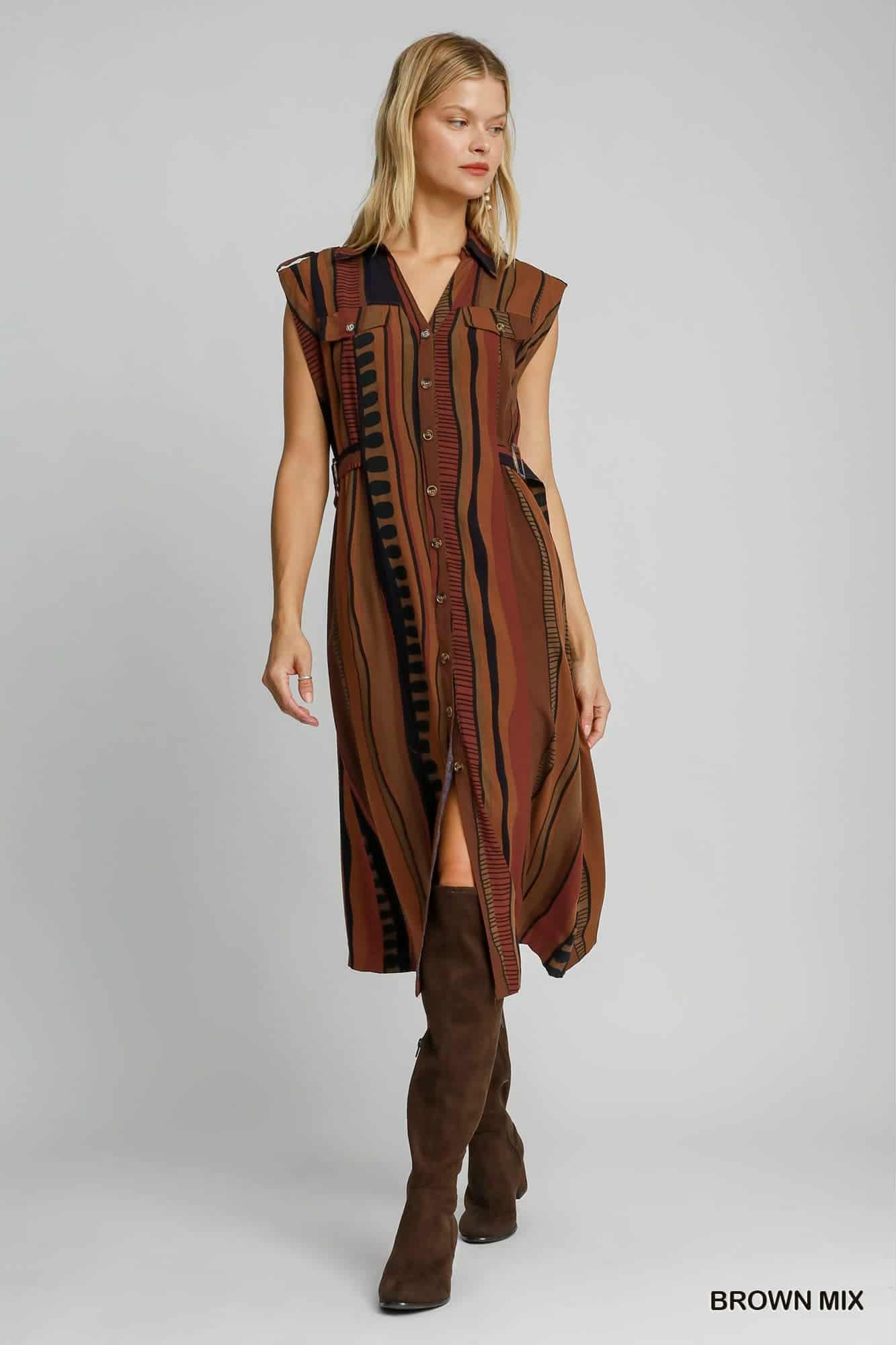 Full view of sleeveless collared brown striped dress styled with boots