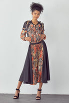 Woman wearing a patterned outfit with a plain background