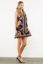 side view of Black sleeveless dress with colorful floral and stripe accents