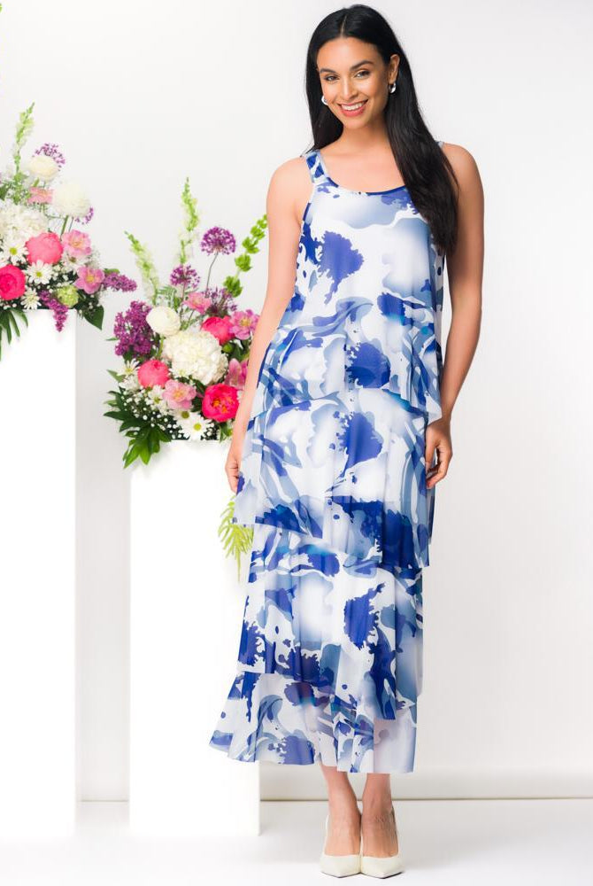 Model wearing Elena Wang blue watercolor mesh tiered maxi dress with sleeveless silhouette styled for elegant resort occasion