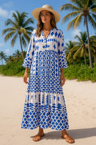 Resort chic woman wearing blue and white long sleeve maxi dress with flowing hem