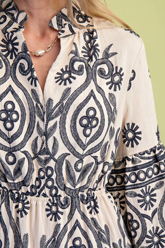 Close-up of a person wearing a patterned dress with a green background