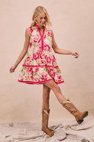 Woman wearing a floral dress and cowboy boots on a beige background