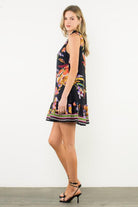 Woman wearing a floral dress with a white background, side view