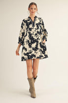 Model wearing Jodifl black and cream floral tunic dress with scalloped trim neckline and ¾ sleeves, photographed against white background— Petunias of Naples