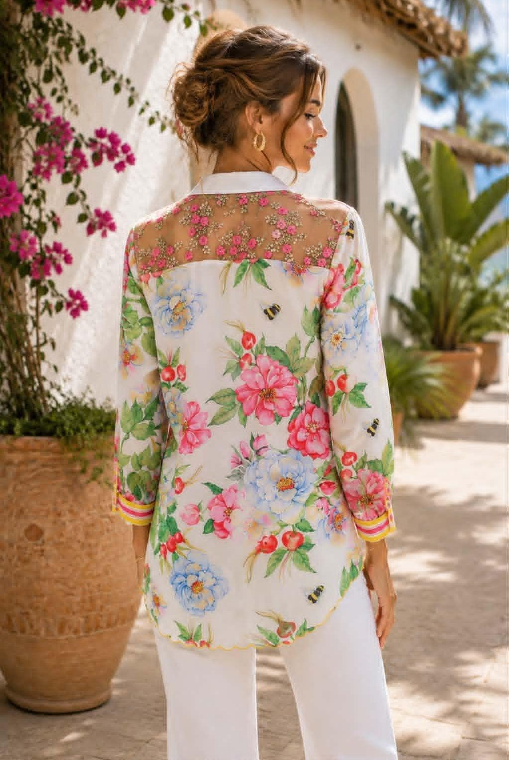 Back of Aratta La Ville Rose blouse featuring a sheer embroidered pink floral yoke, colorful botanical print and striped cuffs.