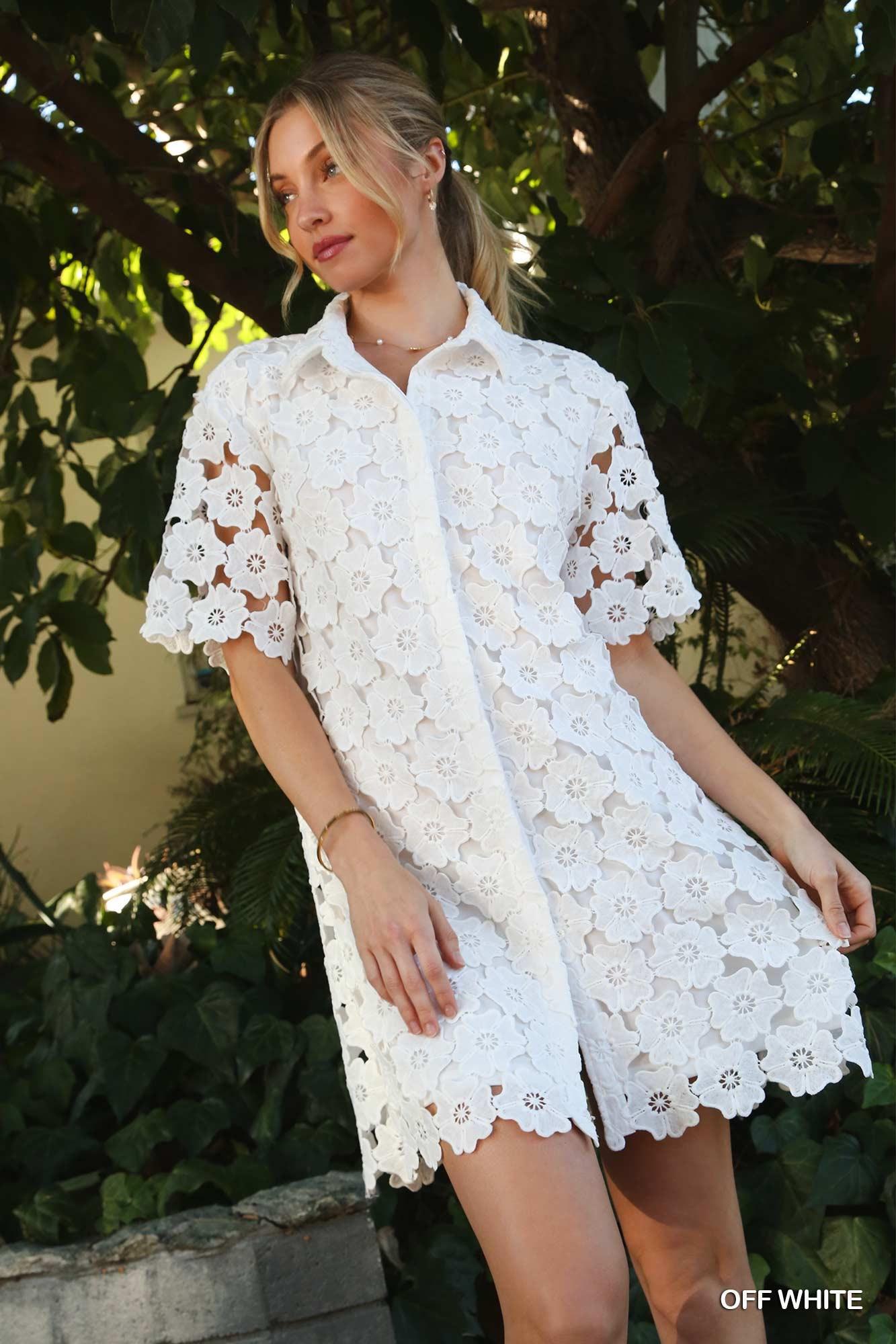 Model wearing off-white floral lace shirt dress with short sleeves and scalloped hem, styled with white sneakers outdoors