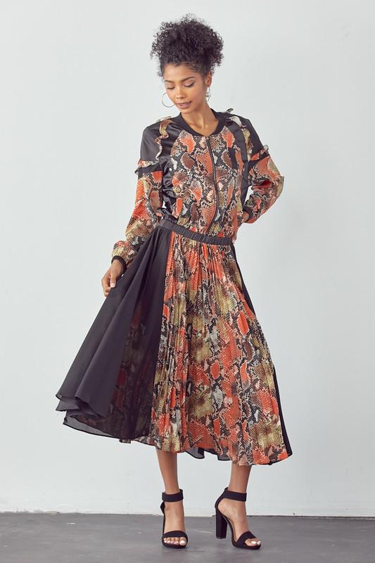 Woman wearing a long, patterned dress with a plain background