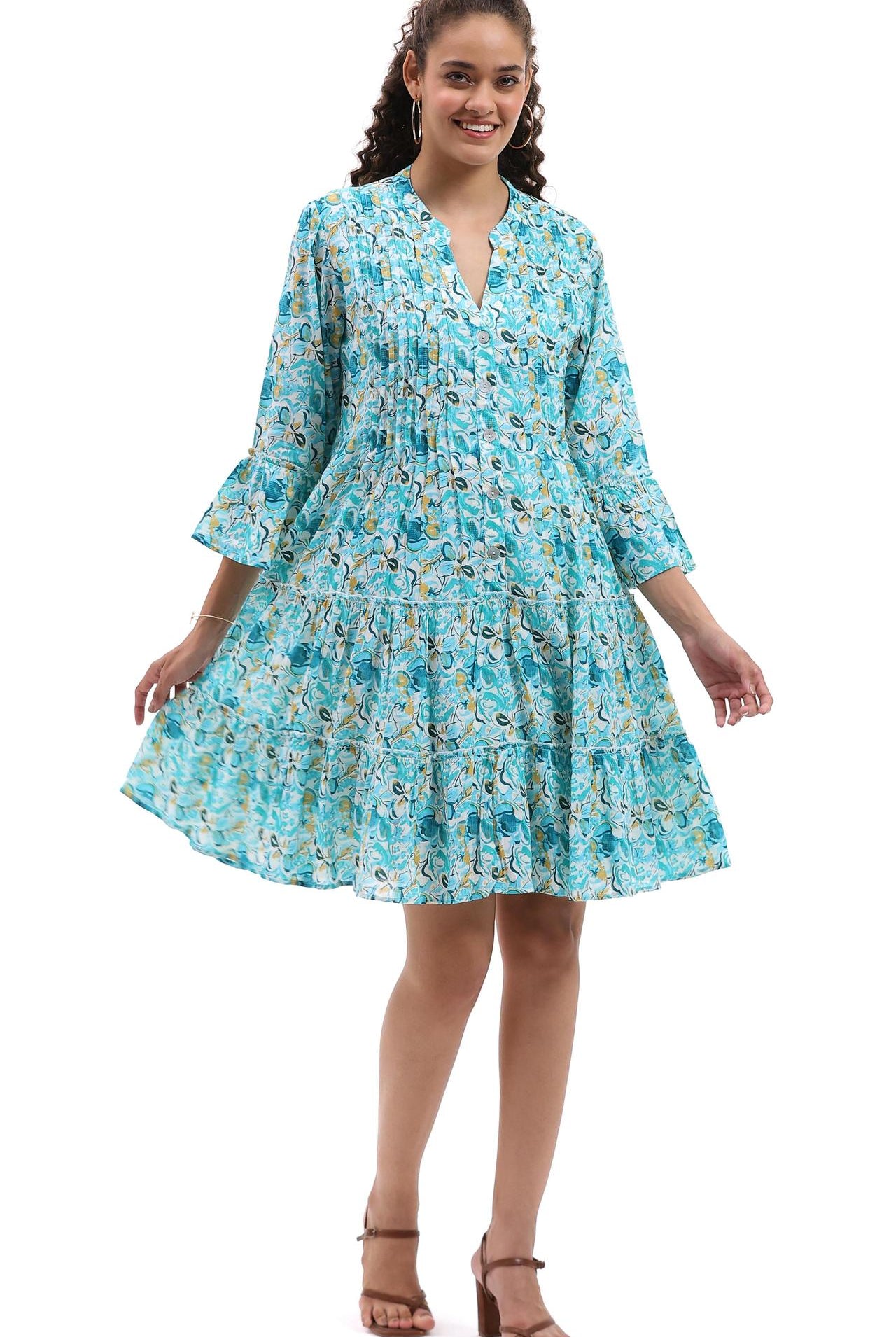Woman wearing a blue floral dress on a white background, Parsley & Sage turquoise floral tiered cotton dress with three-quarter sleeves