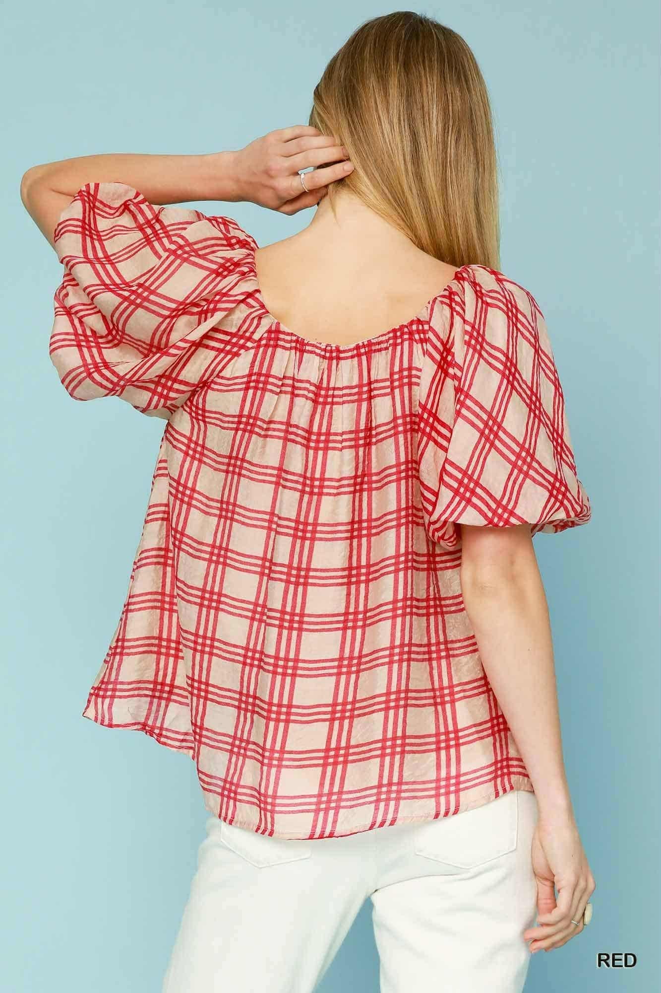 Red and white plaid blouse worn by a person on a light blue background, backview