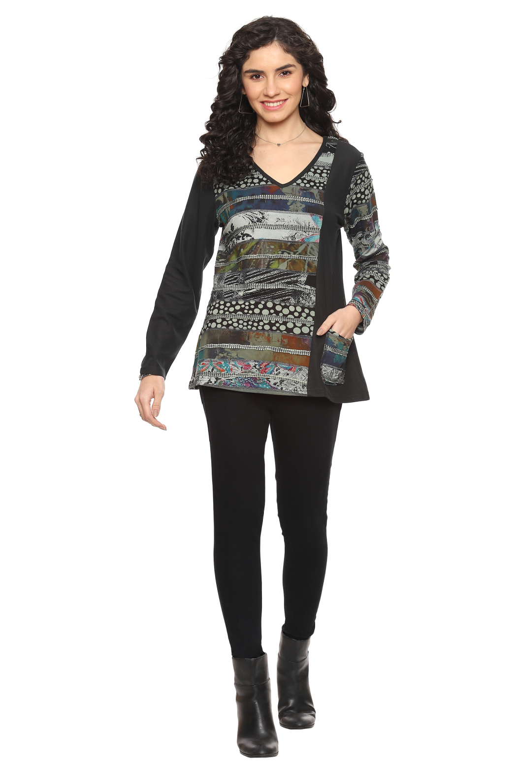 Woman wearing a Parsley & Sage V-neck knit top with artistic patchwork print, long sleeves, and front pocket in earthy tones.