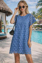 Woman wearing blue circle appliqué resort dress by the pool