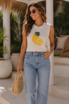 Women's white sleeveless knit sweater featuring a bright lemon graphic and fitted resort-inspired silhouette.