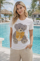 White bling teddy bear tee with crystal embellishments and gold bow worn by resort chic model