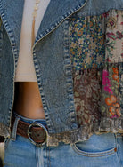 Patchwork denim jacket with floral patterns and a belt closeup