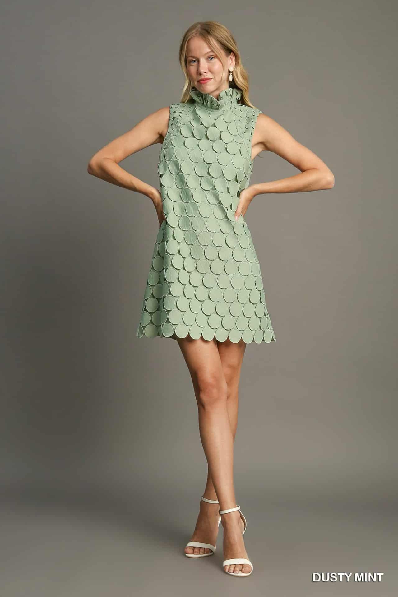 Full view of sleeveless mint green shift dress with round appliqué design.