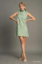 Full view of sleeveless mint green shift dress with round appliqué design.