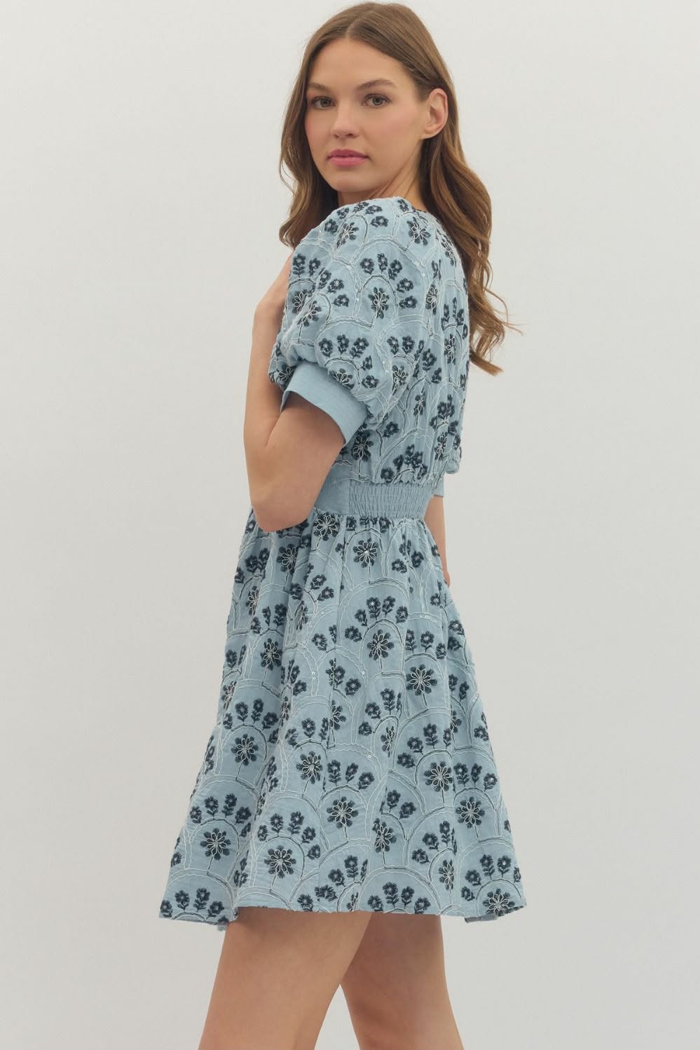 Woman wearing a blue floral dress on a white background