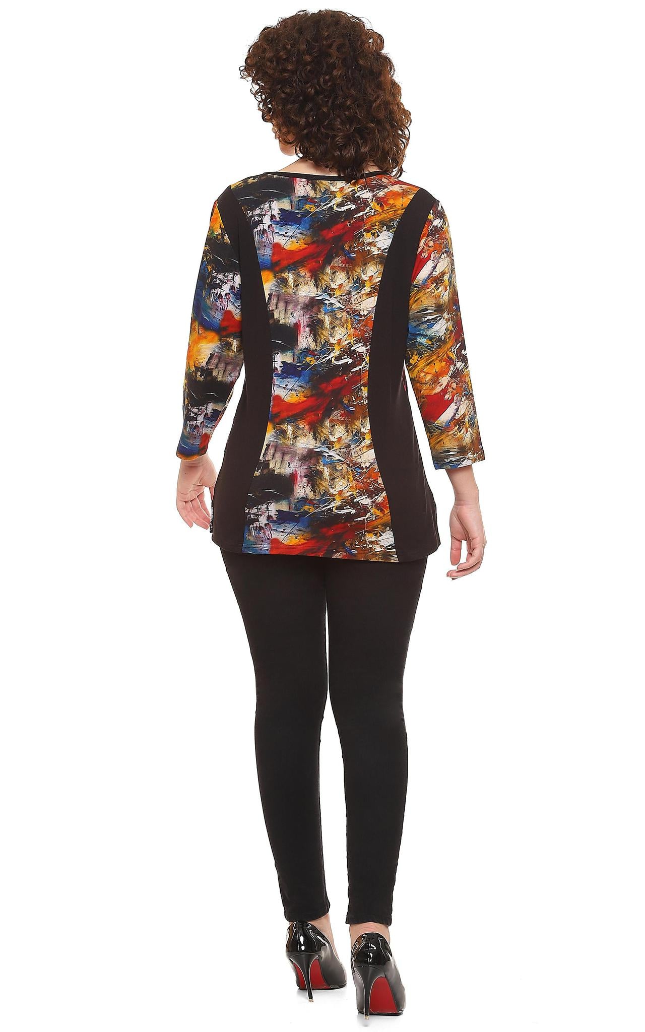 Woman wearing a Parsley & Sage multi-color abstract print V-neck tunic with black geometric stripe design and 3/4 sleeves, paired with black pants.