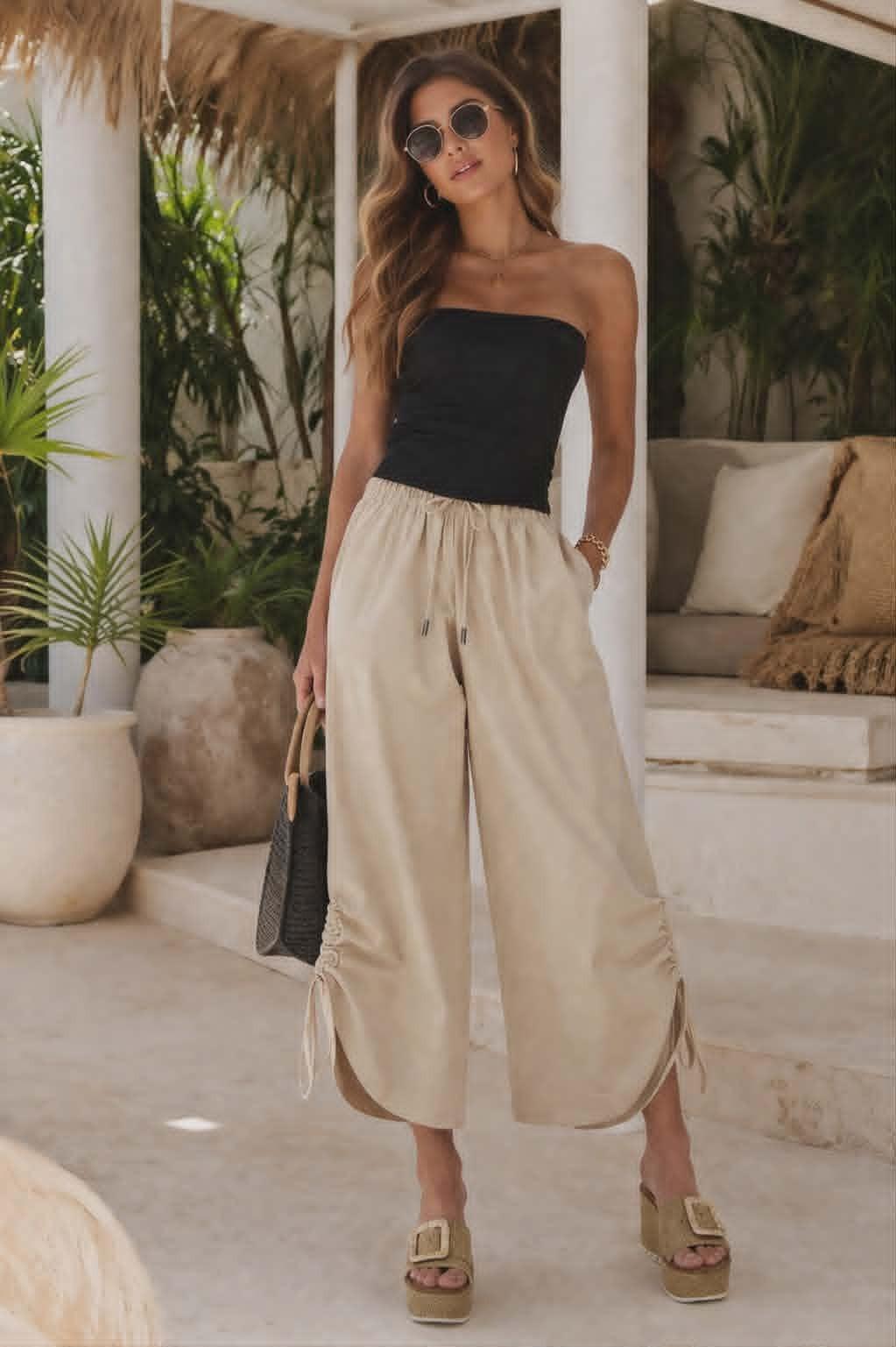 Gabby Isabella beige wide leg cropped pants with drawstring waist and side ruched slit detail styled for a resort chic look