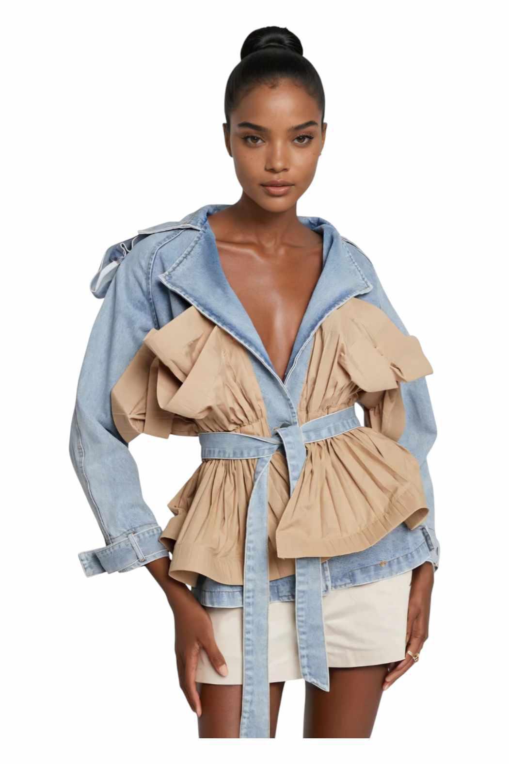 A woman wearing a light blue denim jacket with unique pleated tan fabric accents at the waist and sides, with a belted waist.