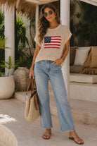 Women's oatmeal open-knit sweater featuring an American flag appliqué patch and relaxed resort-inspired silhouette.